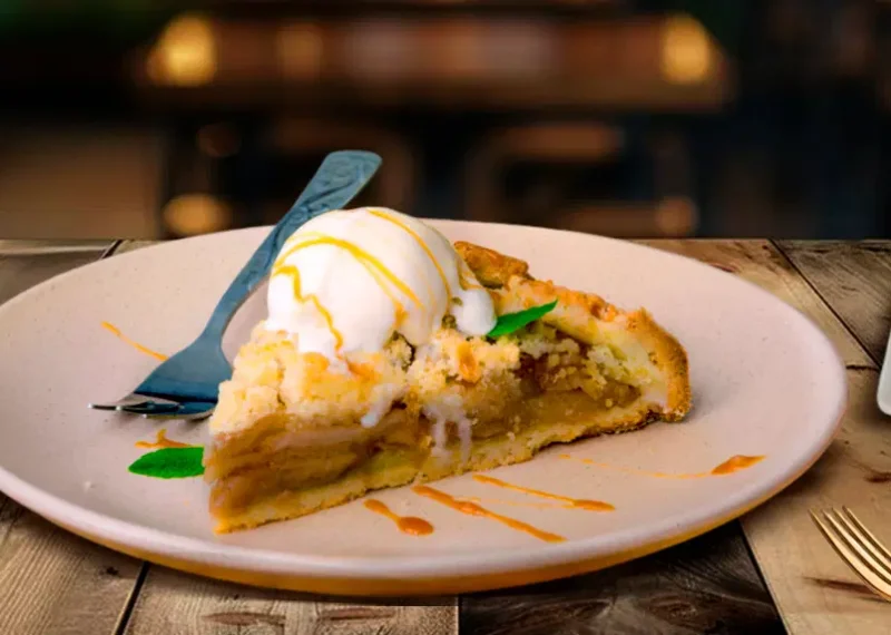 Varios postres de restaurante en exhibición sobre una mesa de madera